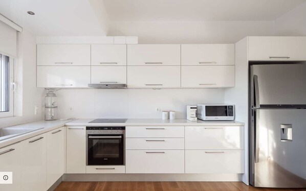 A modern kitchen with white cabinets, a stainless steel refrigerator, a microwave, an oven, and a water dispenser. - ATHENS RIVIERA GRAND PANORAMIC VILLAS I&II LAGONISSI/ PEACEFUL /VIEW SEA SUNSET (Kalivia Thorikou)