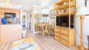 A compact living space with a kitchen, dining area, and entertainment unit.
