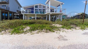 A beachfront property with a large, modern house featuring multiple balconies and large windows. - Purple Pearl - (GVR06919) (Galveston)