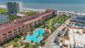 A hotel with a swimming pool, a beach view, and a parking area. - Welcome Inn at Maravilla! (Galveston)