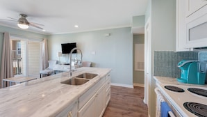 A kitchen with a marble countertop, stainless steel sink, and a teal coffee maker. - Welcome Inn at Maravilla! (Galveston)