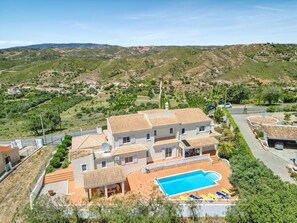 A two-story house with a swimming pool, surrounded by a hilly landscape. - Casa Vista Cumeada - Peaceful Hillside Villa (Silves)