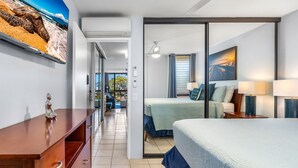 Ein Hotelzimmer mit Bett, Schreibtisch und Fernseher an der Wand.