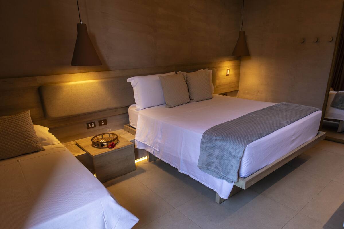 Ein modernes Hotelzimmer mit einem großen Bett, Nachttischen und stimmungsvoller Beleuchtung.