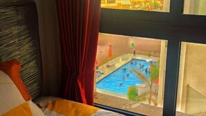 Een hotelkamer met uitzicht op een buitenzwembad.