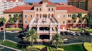 A hotel with a central courtyard, palm trees, and a parking lot. - 2 BEDROOM FAMILY RESORT CLOSE TO DISNEY, CHRISTMAS IN FLORIDA (Kissimmee)