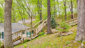 A wooden staircase leading to a cabin in a forested area.