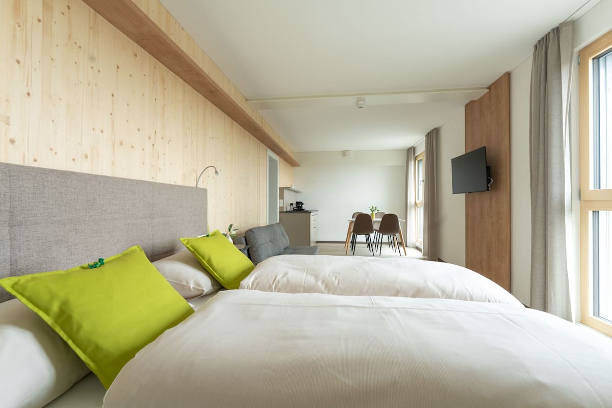 Une chambre d’hôtel avec un grand lit, un bureau et un téléviseur fixé au mur.