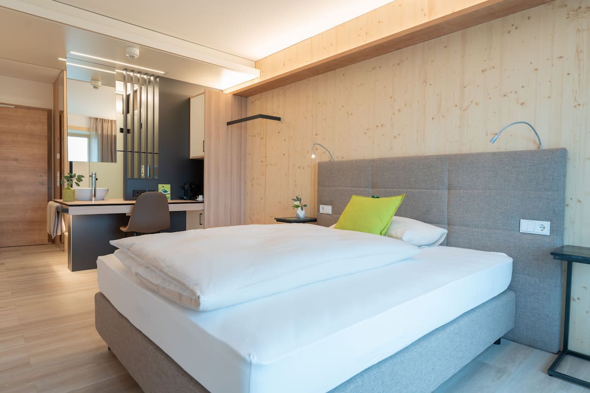 Une chambre d’hôtel moderne, dotée d’un grand lit, d’un bureau et d’une chaise.
