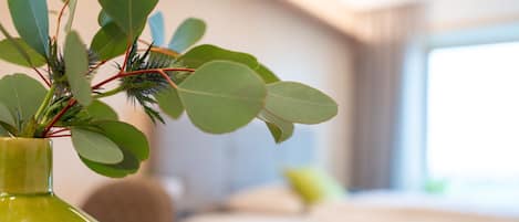 Un florero verde con una planta sobre una mesa en una habitación de hotel.