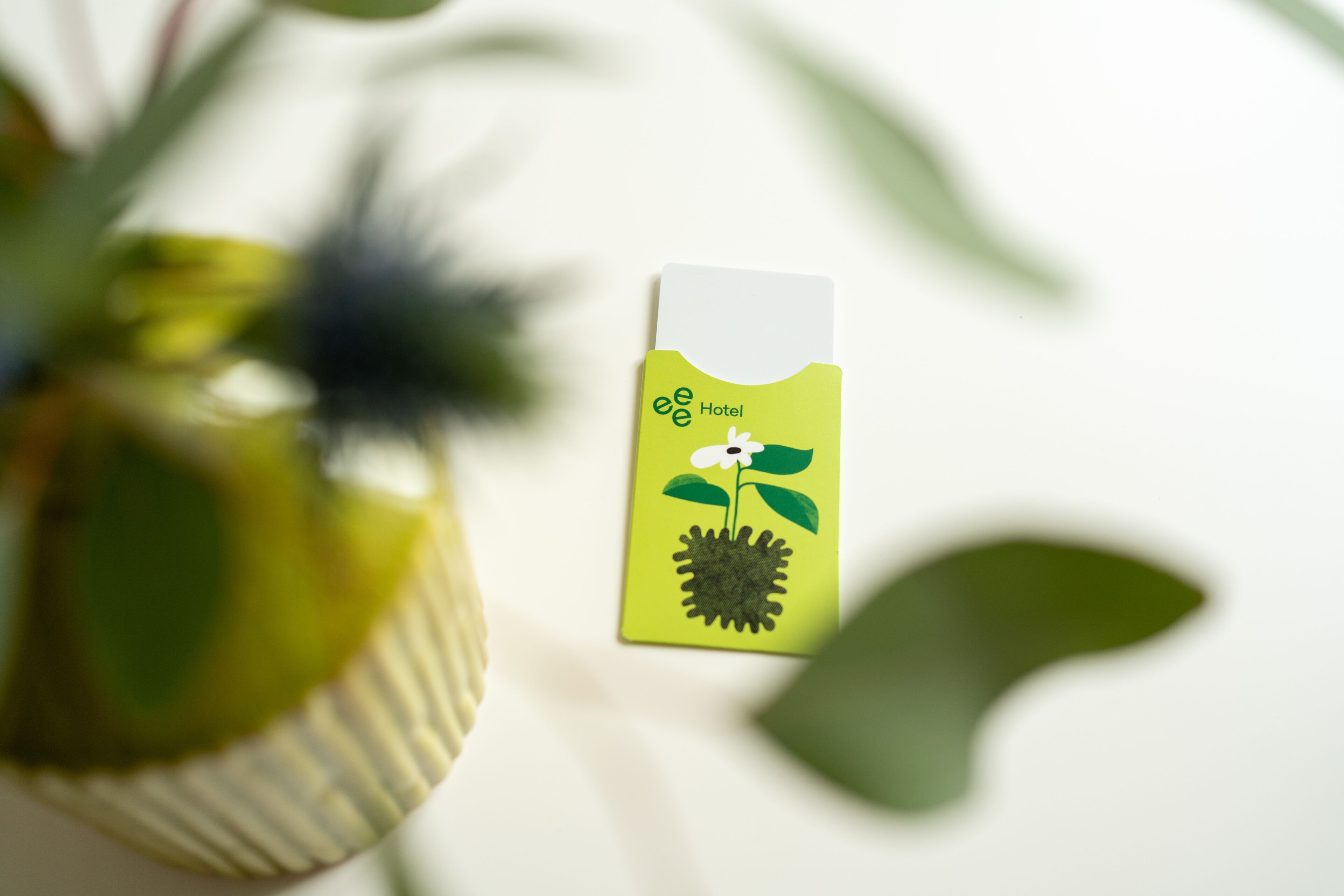 Une carte avec le texte « ee Hotel » et une illustration représentant une fleur et une plante.