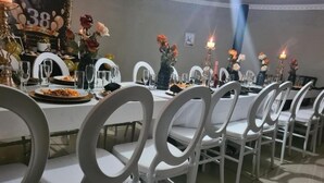 A dining area with white chairs and tables, candles, and floral centerpieces. - Leading Guest Farm  (Margate)