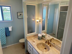 A bathroom with a double sink, a toilet, a window with a view of greenery, and a towel rack with towels. - Sweet Home w Sweet View for the Weekend! (Yakima)