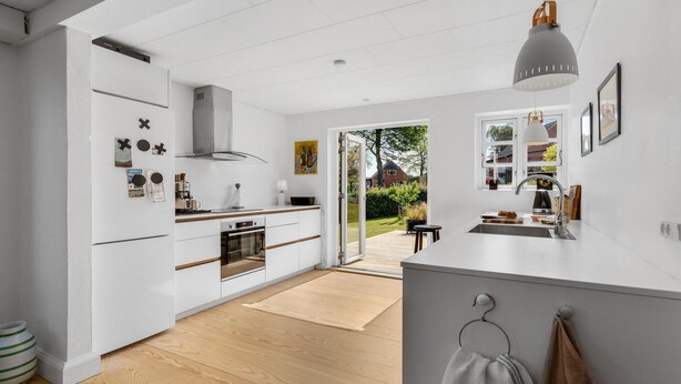 A modern kitchen with white cabinetry, a built-in oven, and a large window. - 4 bedroom amazing home in søby ærø (Søby Ærø)