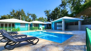 A swimming pool with lounge chairs, a covered area, and a fenced patio. - Casa Arrecife Queen Beds/Beach/Pool/Pet Friendly (Cabo Rojo)