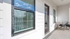 A covered outdoor area with a patio, a sliding glass door, and a seating area with chairs. - Charming Luxury Home near Heights & close to Downtown-The Houston oasis . (Houston)