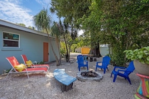 A patio area with outdoor seating, a fire pit, and a building with a 'JW' sign.