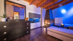 Una sala moderna con chimenea de piedra, un espejo grande y un aparador de madera oscura.