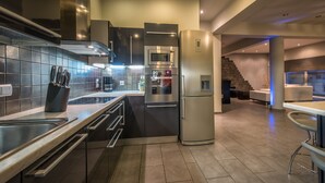 Una cocina moderna con electrodomésticos de acero inoxidable, horno empotrado y refrigerador.