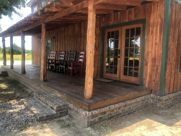 Ein Holzhaus mit Veranda, Stühlen und einer Tür mit Glasschilden.