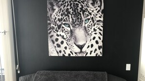 A black sofa with a textured fabric and a dark throw blanket. - Spacious 1 Bed Apartment, parking, gym, pool (Gungahlin)