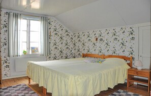Cozy retreat with a single bed, wooden headboard, and a sloped ceiling.