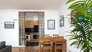 A modern kitchen with wooden cabinets, a built-in oven, and a washing machine. - GuestReady - Trendy stay near Brick Lane Market (London)