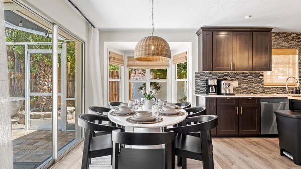 Enjoy meals with family and friends at the round dining table for six, surrounded by a view of the lush garden.