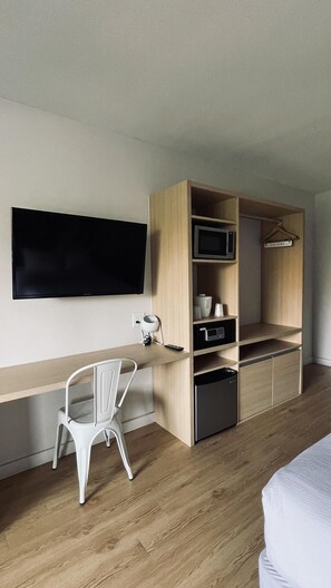 Cozy retreat with a single bed, desk, and flat-screen TV.
