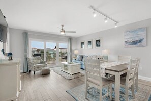 Relax in this stylish living area with a large window, ceiling fan, and comfortable seating for socializing and dining.