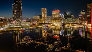 Een stadsgezicht 's nachts met een jachthaven en aangemeerde boten.