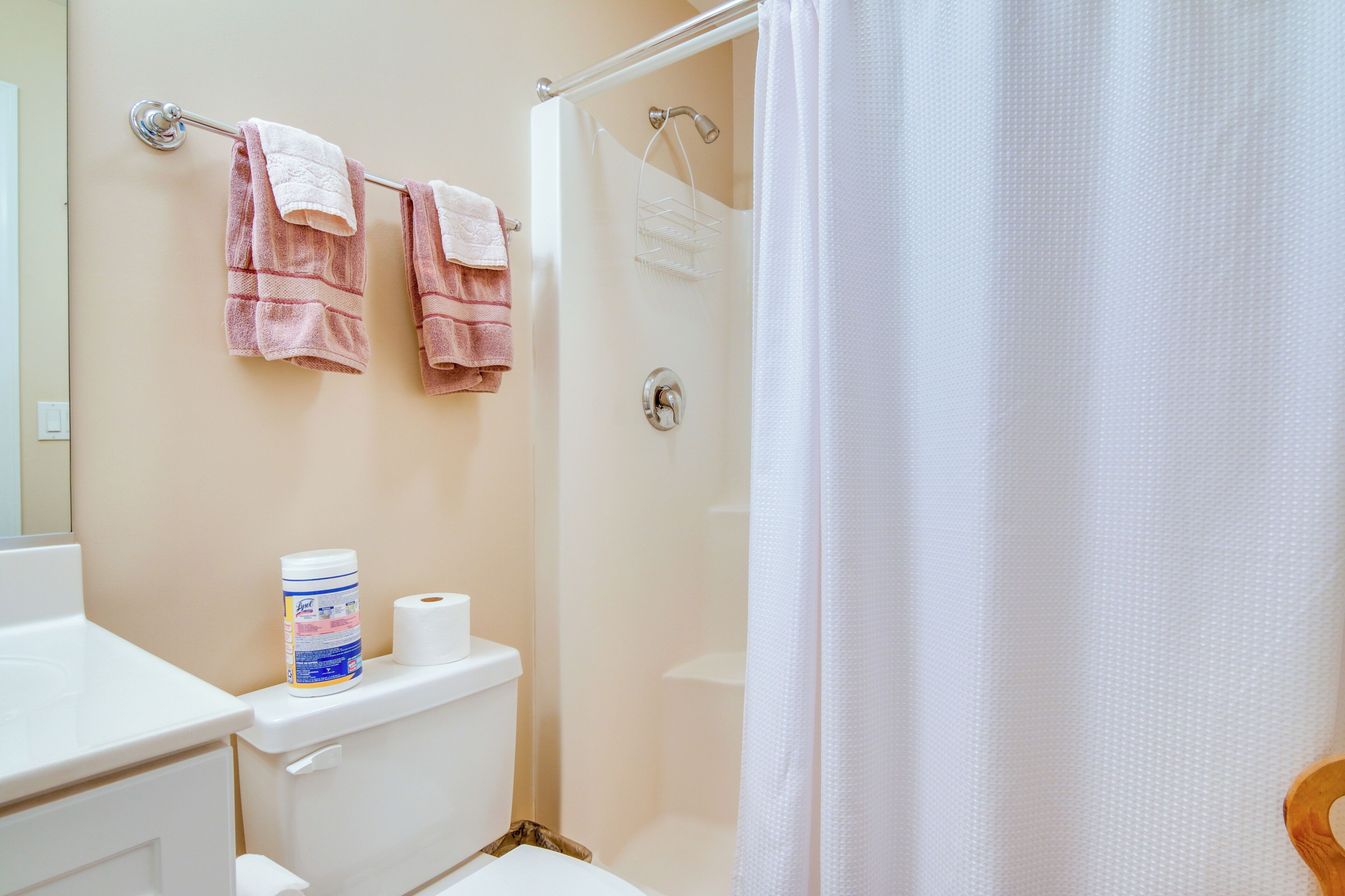 Une salle de bain avec une douche, des toilettes et deux serviettes accrochées au mur.