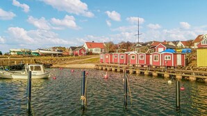 Un port avec des bateaux, une jetée et des bâtiments rouges.