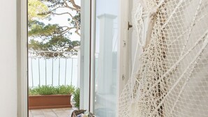 A view through a door into a balcony with a white railing, a wicker basket, and a white netting on the wall. - Home on the sea - Numana, prestigious sky-land with sea view (Numana)