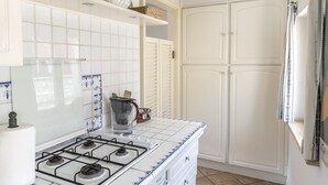 A kitchen with a gas stove, white cabinets, and a tiled backsplash. - Home on the sea - Numana, prestigious sky-land with sea view (Numana)