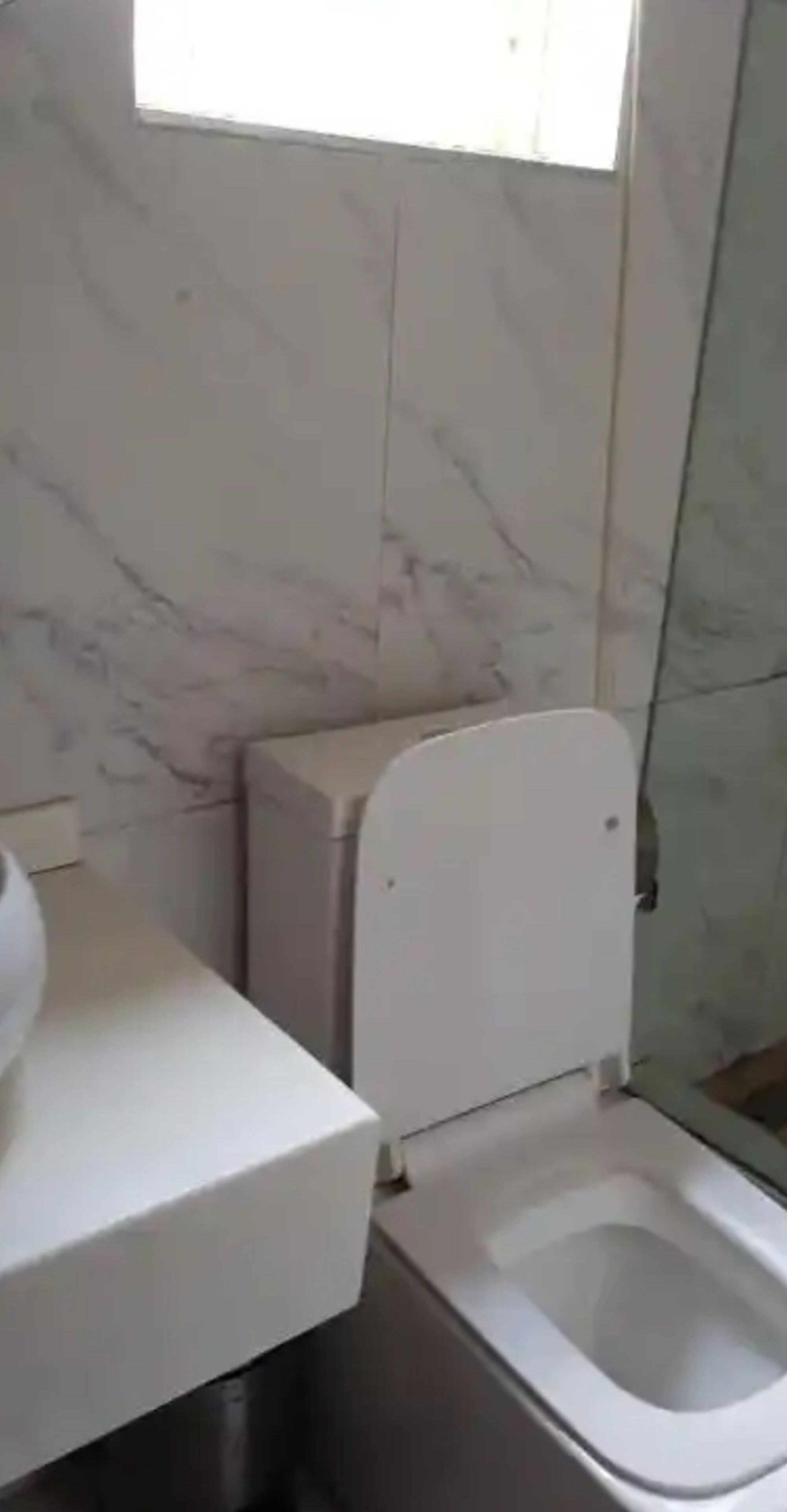 A bathroom with a toilet, a sink, and a shower area.
