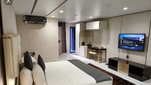 A modern hotel room with a large bed, a desk, a television, and a wardrobe. - Westine Hotels and Spa (Lekki)