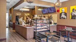 A bakery counter with a menu board, a coffee machine, and a display case with pastries. - Ocean View, 1BD+1.5BA, Steps To Beach. Heated Pool. Ocean reserve (Sunny Isles Beach)