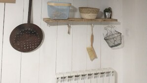 Cozinha com prateleiras de madeira contendo diversos utensílios e recipientes.