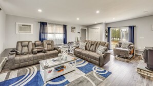 Un salon moderne avec un canapé d’angle, une table basse et un téléviseur.