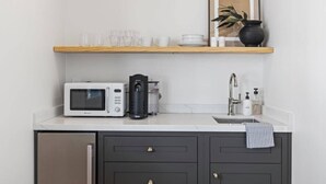 A compact kitchen with a microwave, coffee maker, and a sink. - Casa Jardin (Santa Barbara)