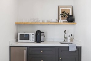 A compact kitchen with a microwave, coffee maker, and a sink. - Casa Jardin (Santa Barbara)