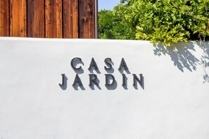 A white wall with the text "CASA JARDIN" in metal letters. - Casa Jardin, a ZenStay Hotel (Santa Barbara)