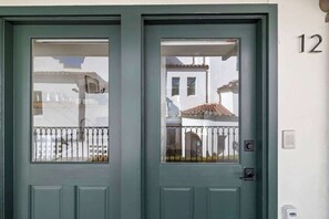 A green double door with a keypad lock and a small window. - Casa Jardin (Santa Barbara)