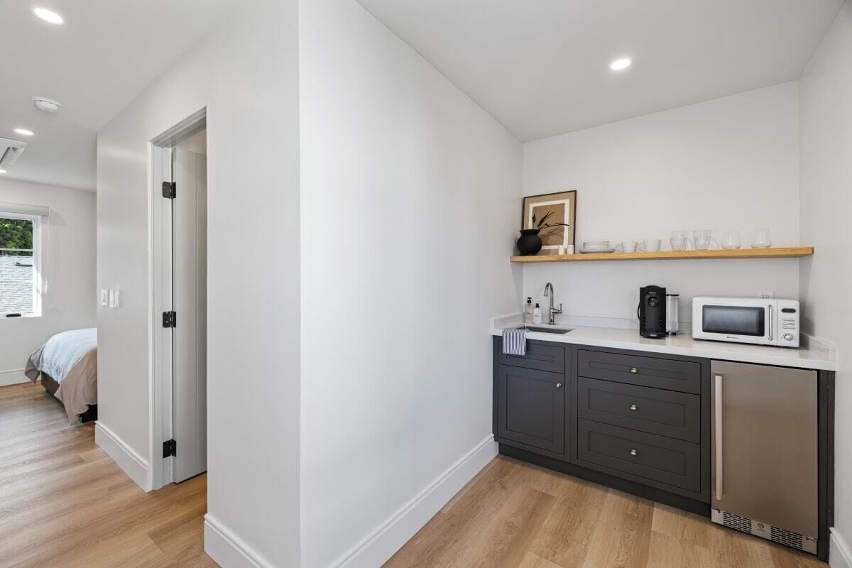 A modern kitchen with a microwave, coffee maker, and a sink.