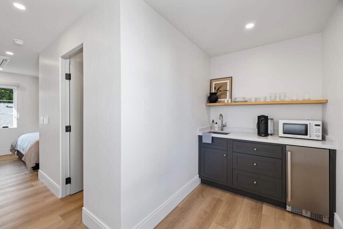 A modern kitchen with a microwave, coffee maker, and a sink.