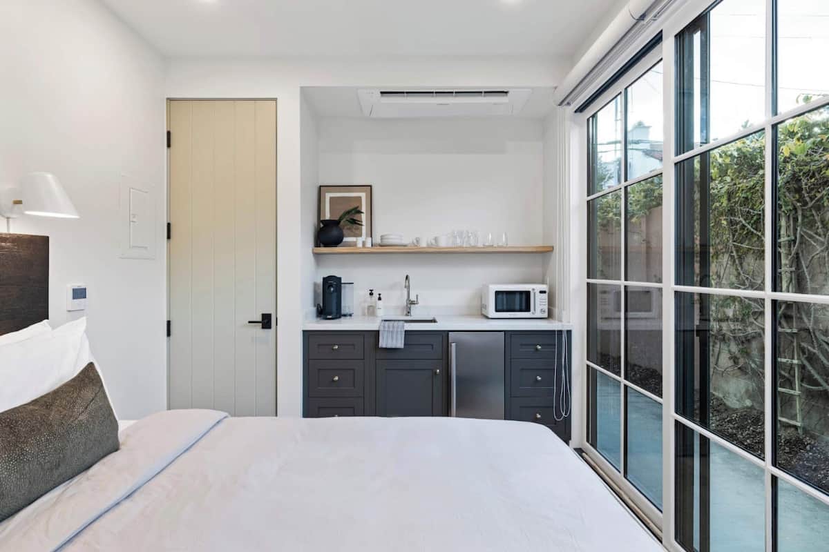 Relax in a serene space with a large bed, wardrobe, and a convenient kitchenette.