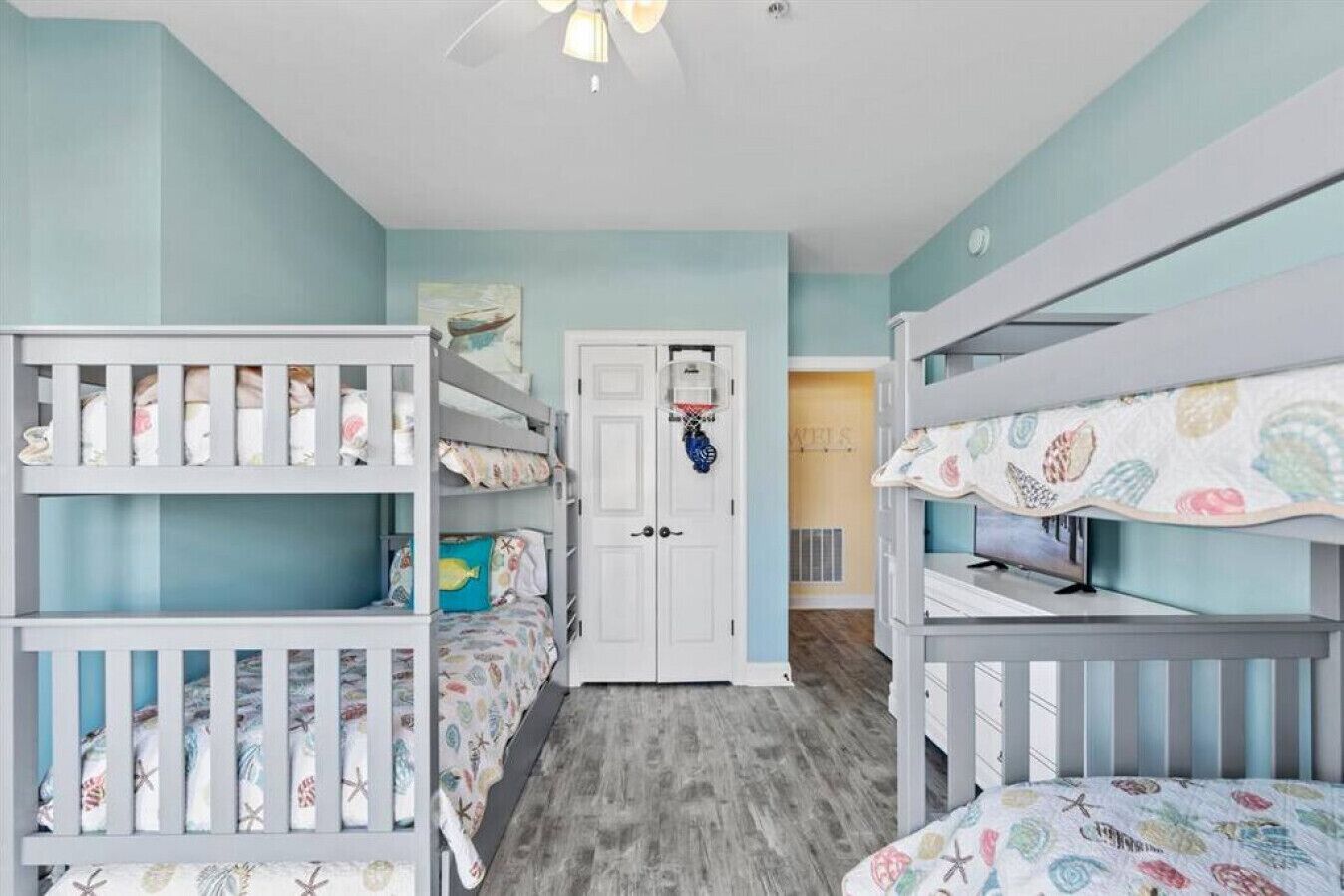 A children's room with bunk beds, a door, and a small hallway.