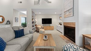 Una sala de estar moderna con sofá, mesa de centro y chimenea.