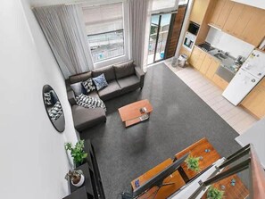 A modern apartment with a living room, kitchen, and balcony.